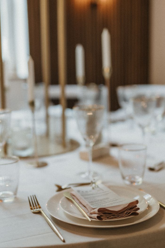 Elegant table setting with candles, glassware, and cutlery for a sophisticated event.