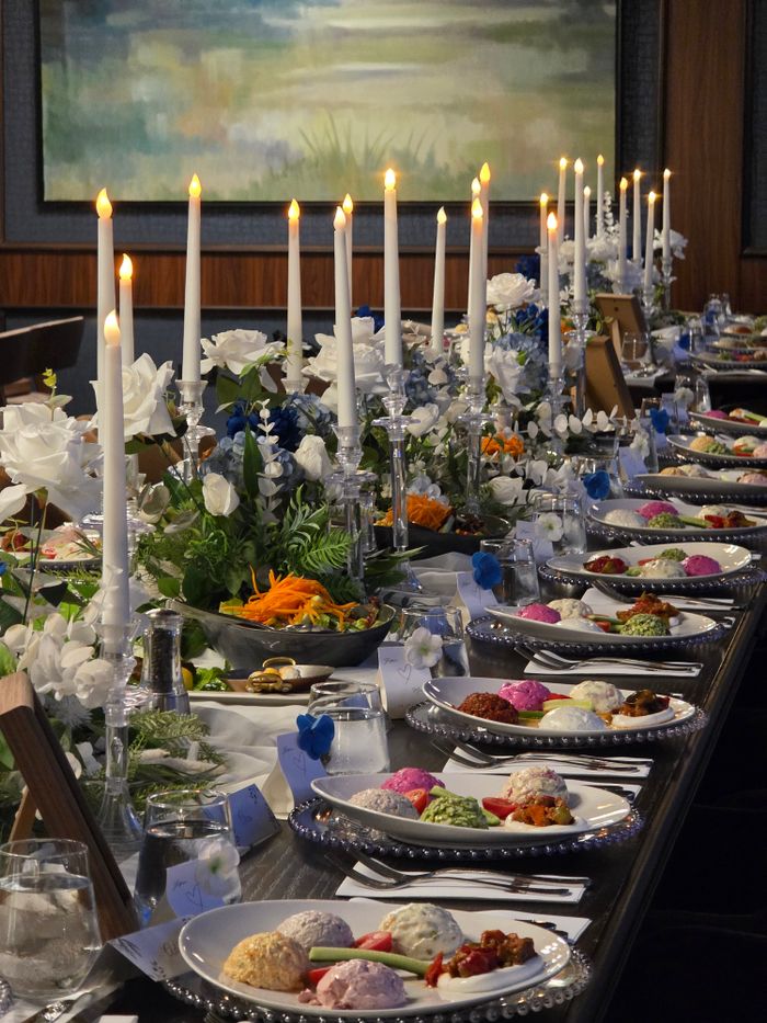 A beautifully set dining table with candles and floral arrangements for a chic evening event.